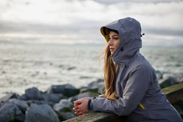 Shoot of young beautiful woman wearing rain jacket in cold weather