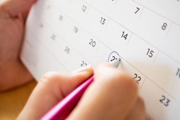 istock calendar page with female hand holding pen 1047316730