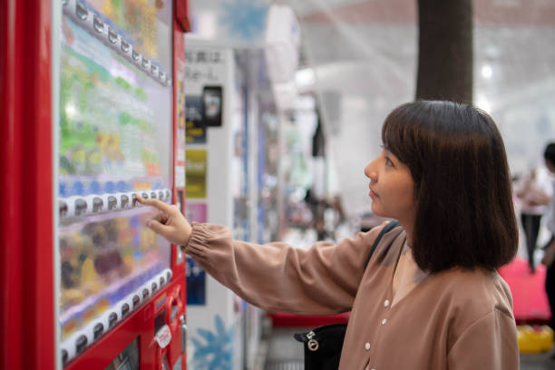 jovem mulher tocando o botão na máquina de venda automática - vending machine fotos - fotografias e filmes do acervo