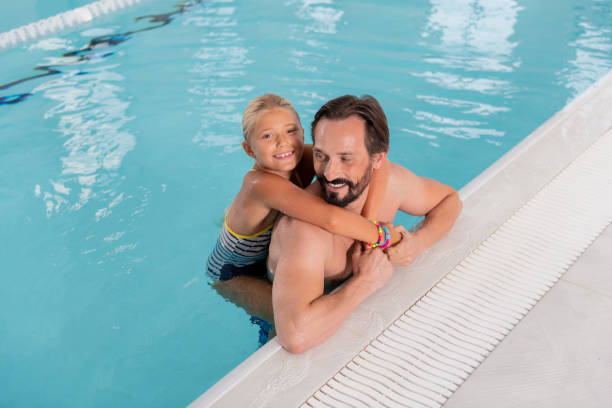 istock Joyful nice girl swimming with her father 1047327694