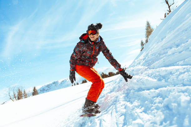 Snowboarder feminino se divertindo na pista de esqui - foto de acervo