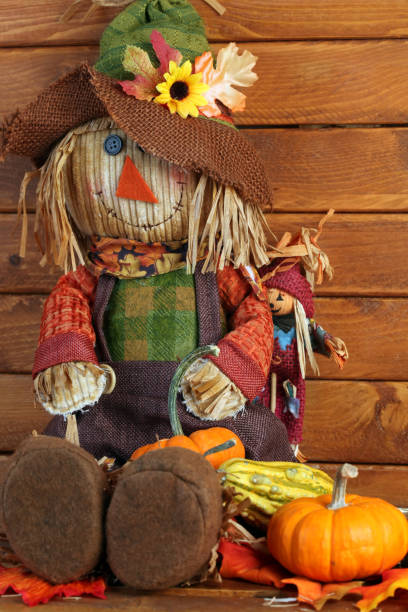 istock Autumn Scarecrow on wooden background 1047335666