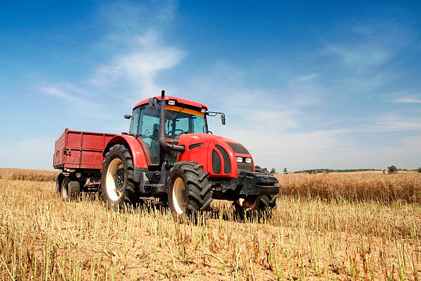 istock Red tractor going through harvested agriculture field 104734688