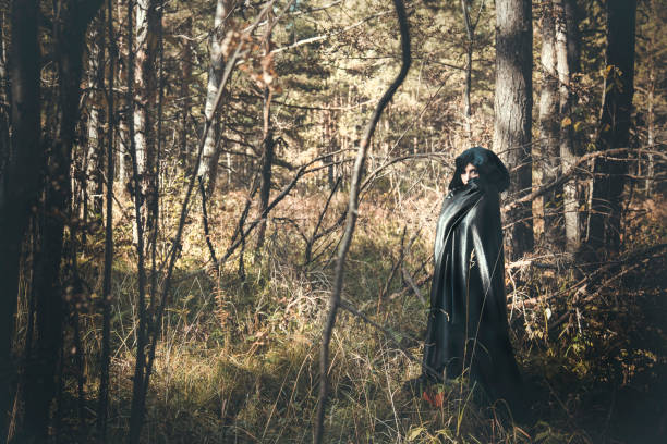 menina morena com olhos vermelhos e vestido vintage laço bordô em imagem de vampiro na floresta de outono - wind textile women retro revival - fotografias e filmes do acervo