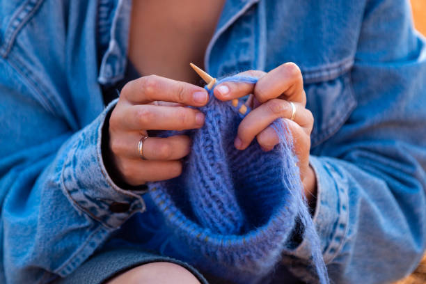 istock A young woman knitting 1047371792