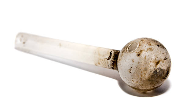 Meth Pipe View of a glass pipe used to smoke illegal drugs.  This particular pipe was confiscated by police and was used to smoke methamphetamine.  Image shot at the police station.  Focus on round end with natural shadow. pipe smoking pipe stock pictures, royalty-free photos & images