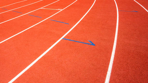 istock red running track on athletic stadium background texture 1047380688