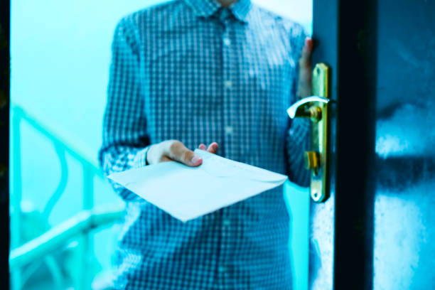 young postman brings the letter envelope delivery to home