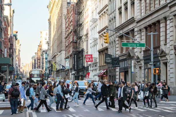 Crowds of people in SoHo New York City NEW YORK CITY, CIRCA 2018: Busy crowds of people walk across the intersection of Broadway and Spring Street in the SoHo neighborhood of Manhattan, NYC. soho new york stock pictures, royalty-free photos & images
