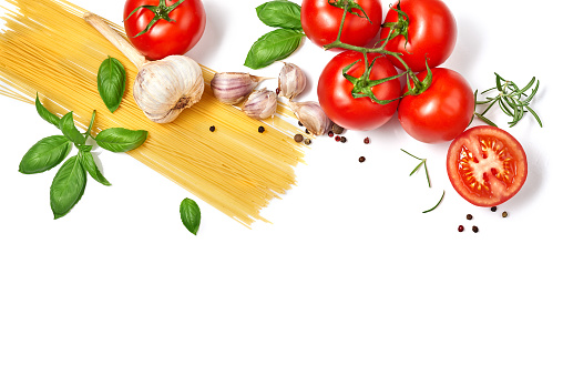 Spaghetti pasta with tomatoes garlic and basil isolated on white background. Top view.