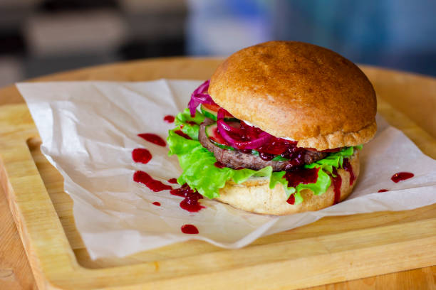 istock Meat Burger with pickled onions, cutlet and cranberry jam on woo 1047421746