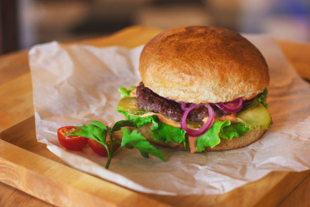 istock Fresh meat Burger with pickled onions on wooden Board 1047421806