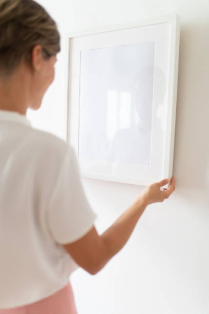 istock Holding white picture frame hung on the wall 1047428146