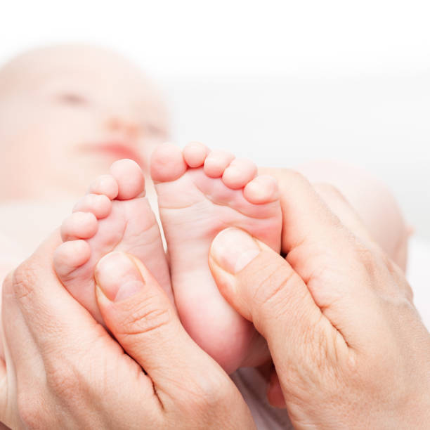 piccolo bambino che riceve un massaggio ai piedi chiropratico o osteopatico - reflexology human foot physical therapy massaging foto e immagini stock