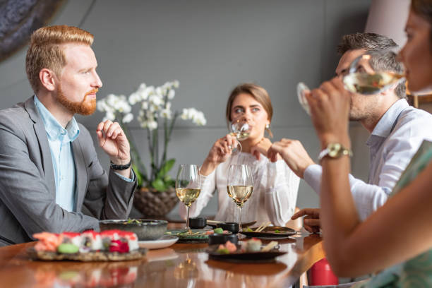 istock Businesspeople discussing and drinking over lunch 1047437416