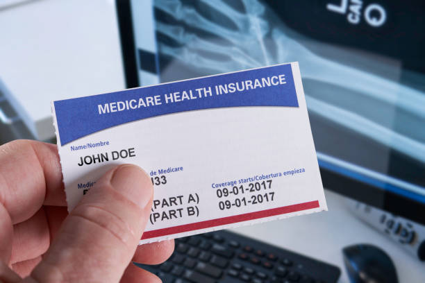 carte d’assurance maladie medicare en cabinet médical avec radiographie et tenant à la main - cards photos et images de collection