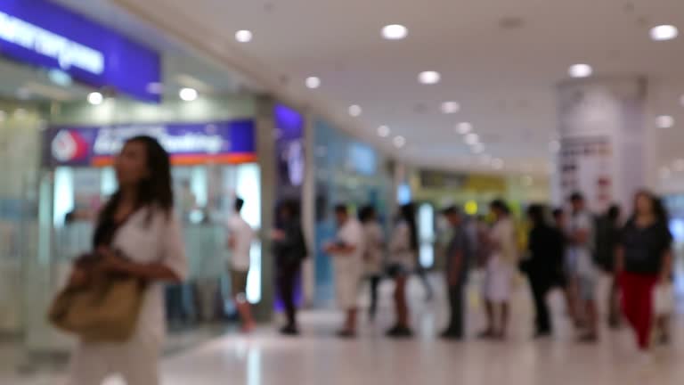 Blur or Defocus Background of People line up to use Banking Machine or ATM(Automatic Teller Machine) to Deposit, Withdraw and Transfer Money