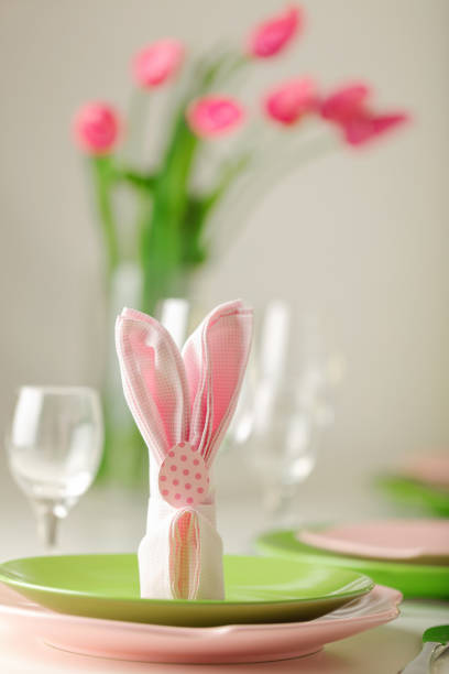 istock Happy easter. Decor and table setting of the Easter table is a vase with pink tulips and dishes of pink and green color. 1047453160
