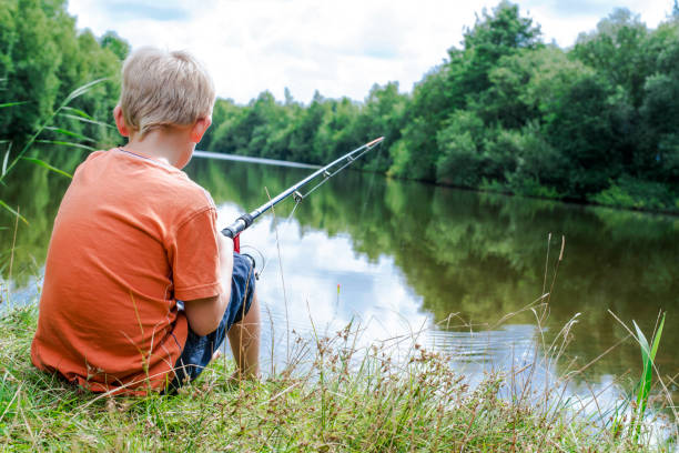istock Young boy fishing at lake 1047455718