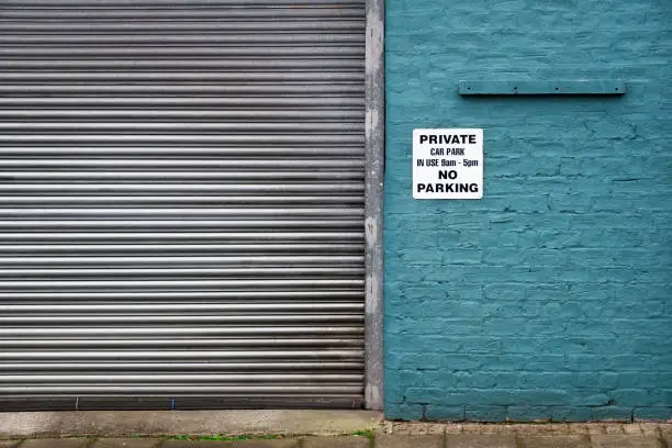 Photo of No parking private sign at factory car garage door