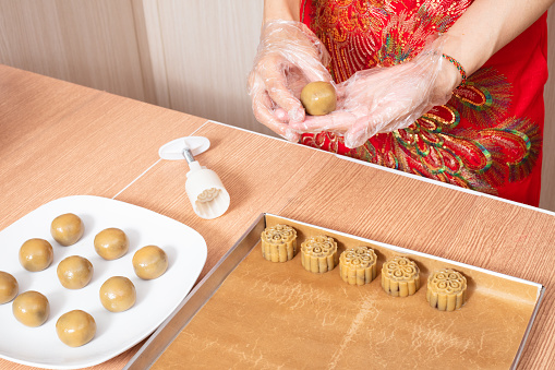 Asian chinese woman making moon cake in the kitchen at home