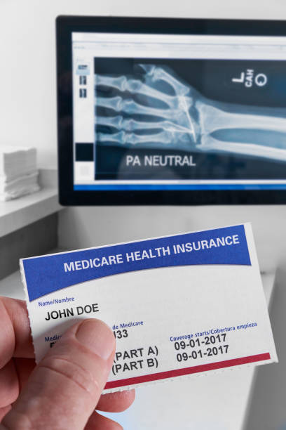 medicare health insurance card w gabinecie medycznym z x-ray i trzymania ręki - doctors office adult break caucasian zdjęcia i obrazy z banku zdjęć