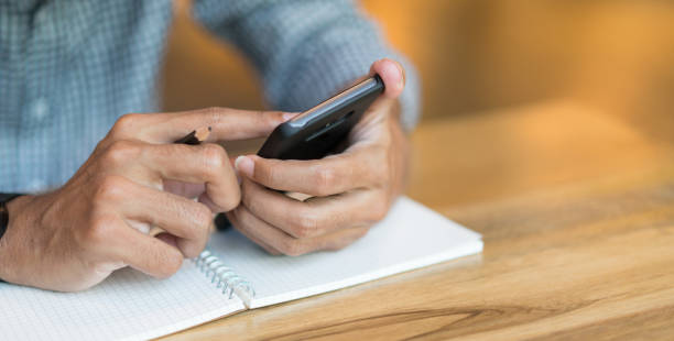 istock close up business man holding smart phone for working or checking assignment from company at office desk in relax time , lifestyle concept 1047475894