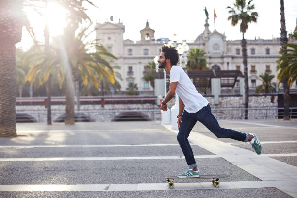 hipster con tabla larga - patinaje en tabla larga fotografías e imágenes de stock