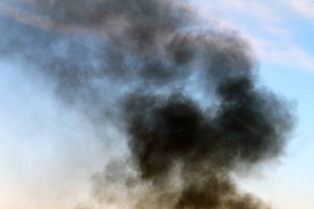 istock black smoke on the light sky background. 1047476194