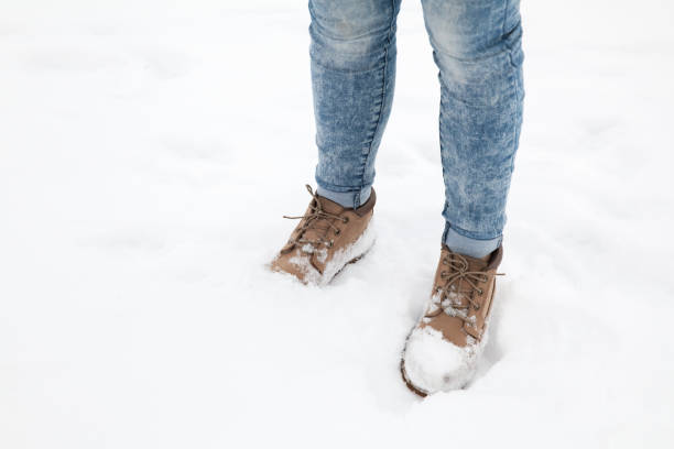 istock Female feet in blue jeans and high boots 1047478568