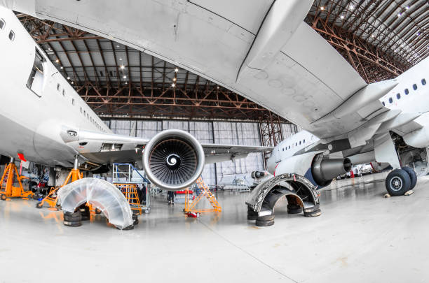 aerei nella riparazione e manutenzione dell'hangar, vista da sotto l'ala dell'aereo. - hangar foto e immagini stock