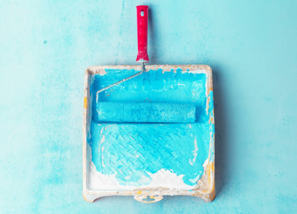 istock Tray paint and paint roller color light blue. Creative background 1047482414