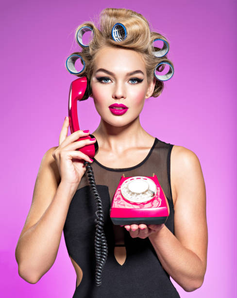 istock Young attractive woman with blue culers using an old phone. 1047484128