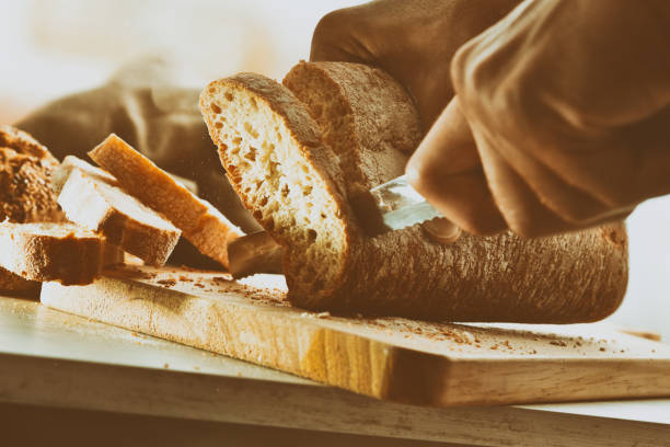 istock Chef slicing bread in slices on a cutting board vintage 1047484306