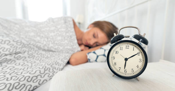 despertador analógico. mujer durmiendo en la cama - wide awake fotografías e imágenes de stock