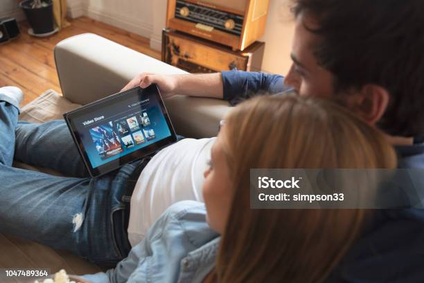 Couple Using Digital Tablet For Watching Movie On Vod Service Stock Photo - Download Image Now