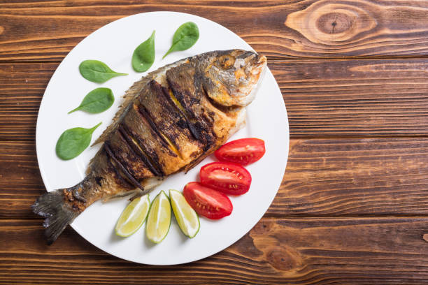istock Fried fish dorado with lime , tomatoes and spinach 1047494252