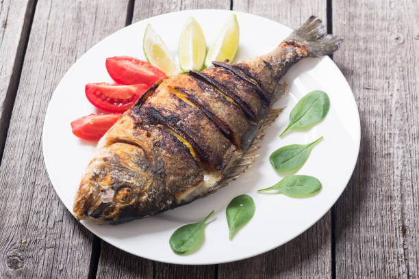 istock Fried fish dorado with lime , tomatoes and spinach 1047494260