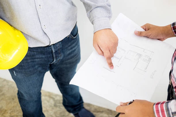 istock Midsection Of Architects Discussing Over Blueprint While Standing In Office 1047494536