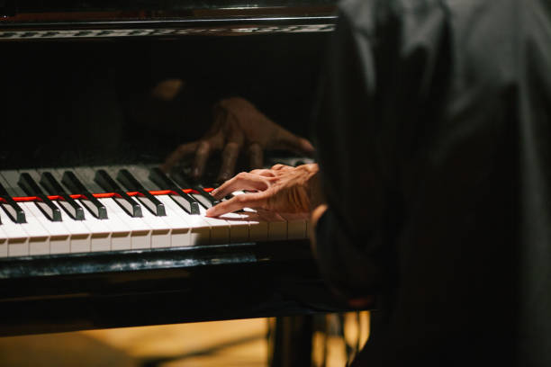istock Midsection Of Man Playing Piano 1047498524