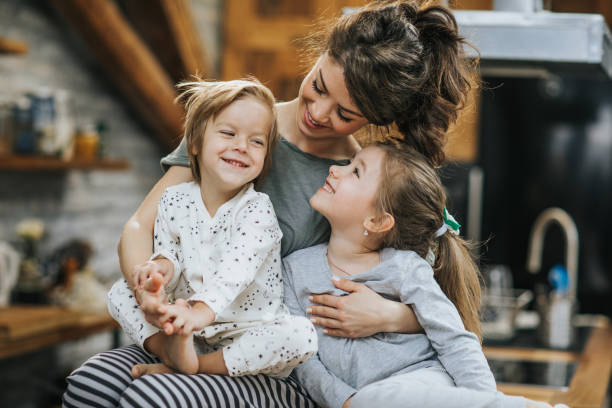 Happy mother spending time with her small kids at home. Young happy mother enjoying in time with her small children at home. family with two children stock pictures, royalty-free photos & images