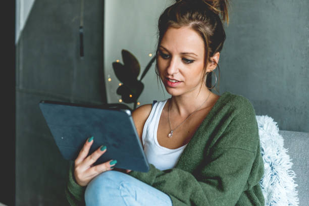 istock Smiling woman looking at digital tablet 1047504462
