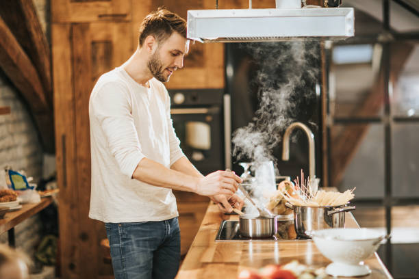 istock Happy bachelor preparing lunch in the kitchen. 1047504948