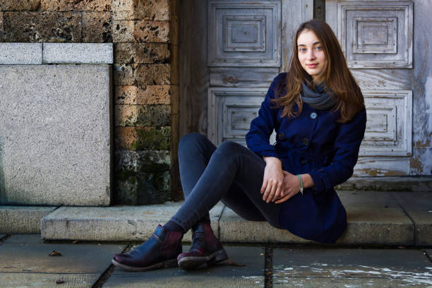 beautiful girl sitting in front of an old door