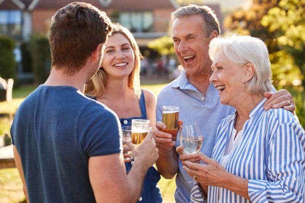 genitori con prole adulta che si godono un drink estivo all'aperto al pub - giardino di birra foto e immagini stock