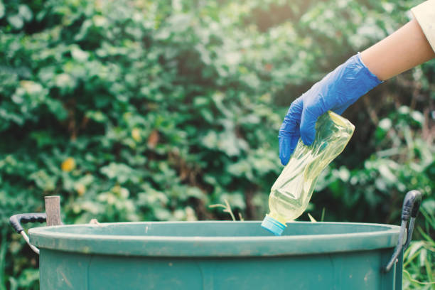 istock Cropped Image Of Hands Throwing Plastic Bottle In Garbage Can 1047513506