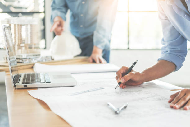 istock Midsection Of Architects Working On Blueprint 1047513812