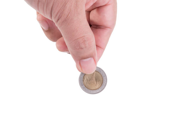 istock Cropped Hand Holding Coin Against White Background 1047515054