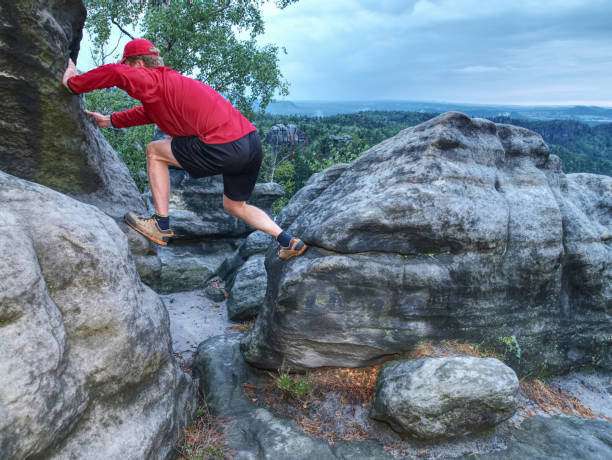 istock Man hiker with trekking clothes on a top. Fall nature. 1047515210