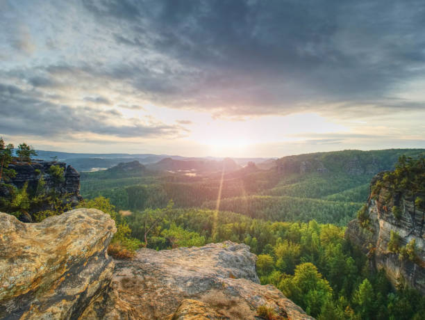 istock Mountain valley during golden sunrise. Clouds over the forest 1047515276